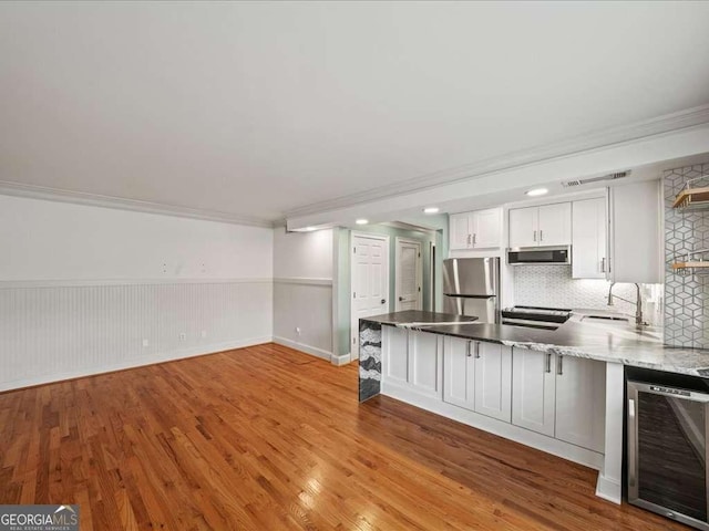 kitchen with white cabinetry, sink, wine cooler, stainless steel fridge, and light hardwood / wood-style flooring