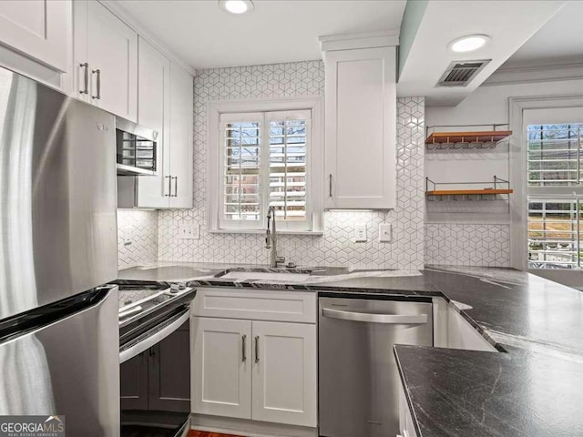 kitchen with appliances with stainless steel finishes, sink, and white cabinets