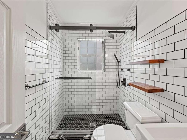 bathroom featuring a shower with door and toilet