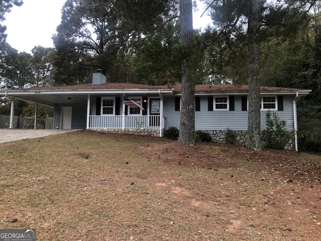 view of front of house with a carport, covered porch, and a front yard