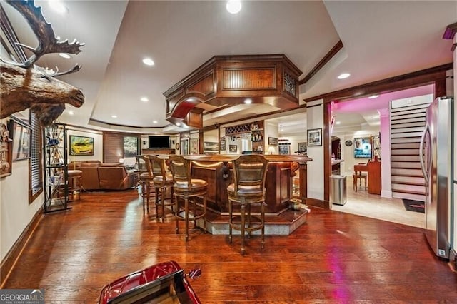 bar featuring hardwood / wood-style floors, stainless steel fridge, and a tray ceiling