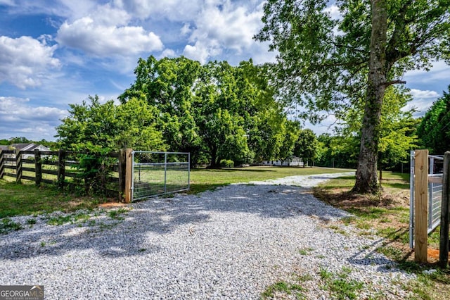 view of gate with a lawn