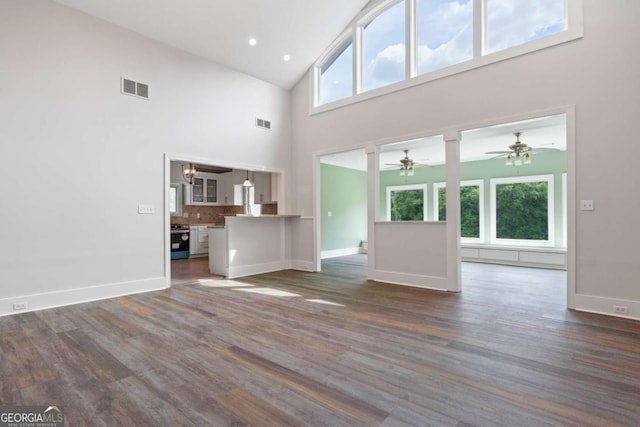 unfurnished living room with ceiling fan, plenty of natural light, and dark hardwood / wood-style flooring