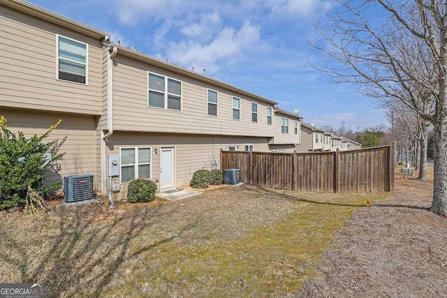 back of house featuring a yard and central AC unit