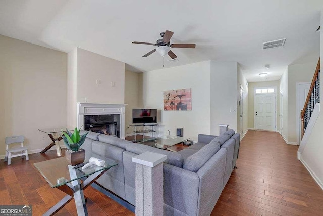 living room featuring ceiling fan, a high end fireplace, and hardwood / wood-style floors