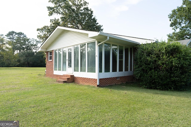 view of side of home featuring a yard and a sunroom