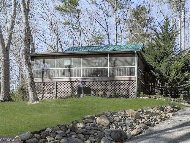 view of front facade featuring a front lawn and a sunroom