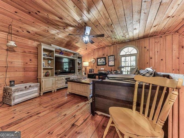 interior space featuring vaulted ceiling, wood walls, ceiling fan, wooden ceiling, and light hardwood / wood-style flooring