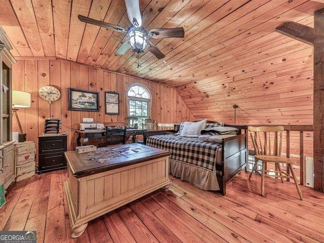 bedroom featuring vaulted ceiling, wooden ceiling, wooden walls, and light wood-type flooring