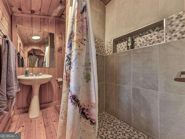 bathroom featuring wood ceiling, wood-type flooring, wooden walls, and curtained shower