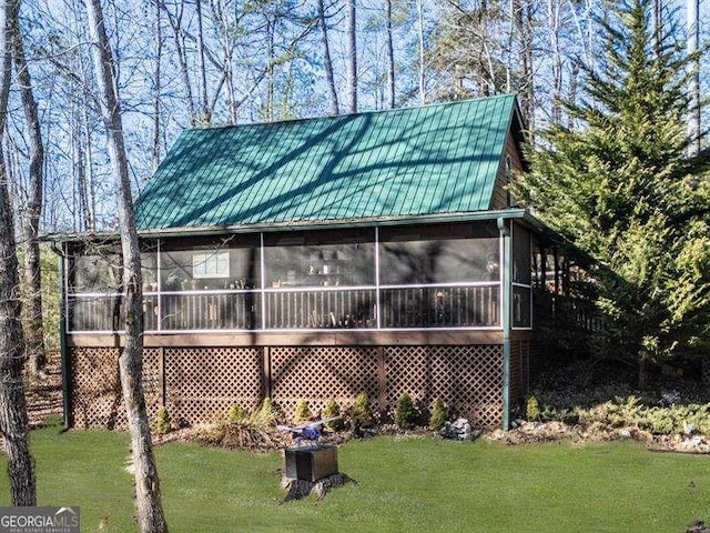 exterior space featuring a sunroom and a lawn