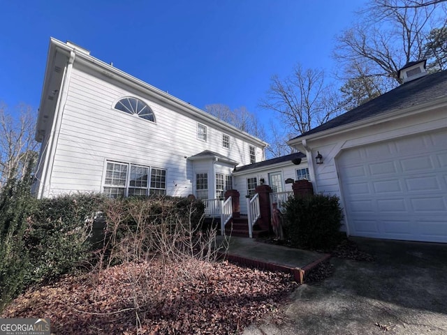 view of property exterior featuring a garage and a deck