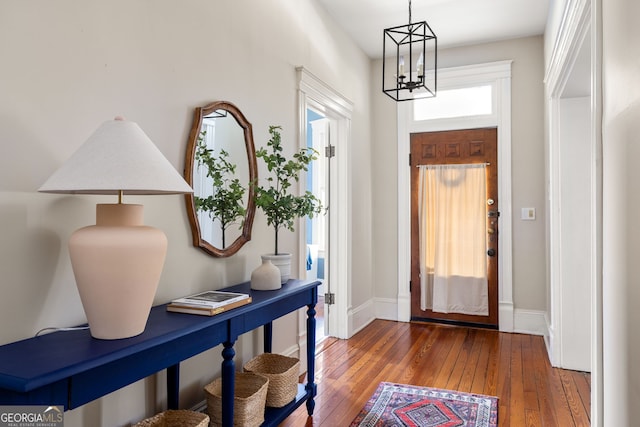 foyer with dark wood-type flooring and a chandelier