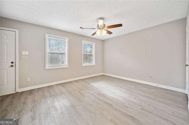 unfurnished room with ceiling fan, a textured ceiling, and light wood-type flooring