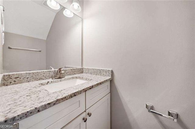 bathroom with vanity and lofted ceiling