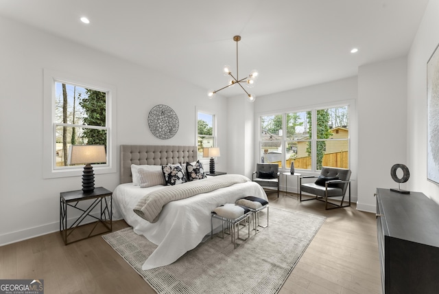 bedroom featuring recessed lighting, a notable chandelier, baseboards, and wood finished floors