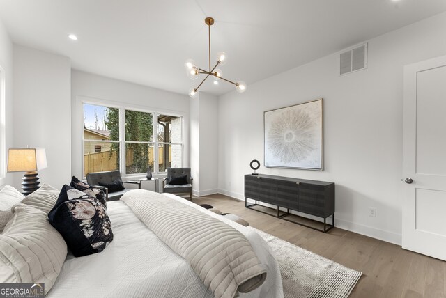 bedroom featuring hardwood / wood-style flooring and a chandelier