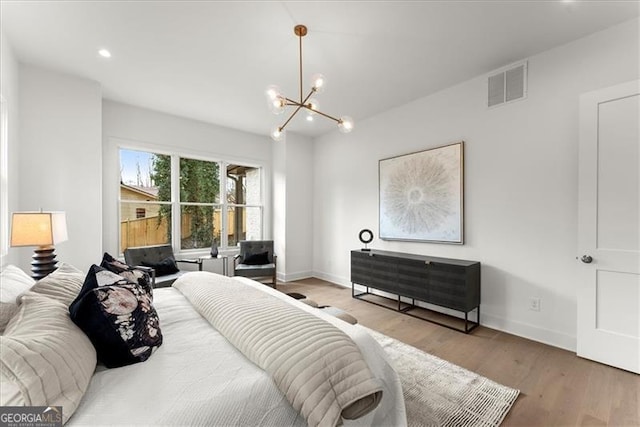 bedroom featuring hardwood / wood-style floors and a chandelier