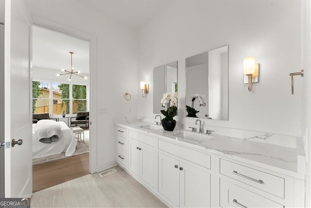 bathroom with vanity, hardwood / wood-style floors, and a chandelier