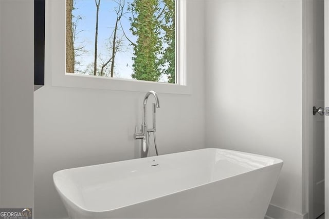 bathroom featuring a tub to relax in and sink