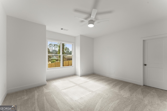 spare room with baseboards, visible vents, and light colored carpet