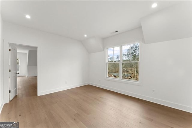 additional living space featuring hardwood / wood-style flooring and lofted ceiling