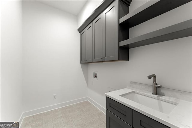 washroom with cabinets, washer hookup, and sink