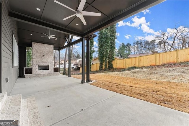 view of patio / terrace featuring ceiling fan and a fireplace