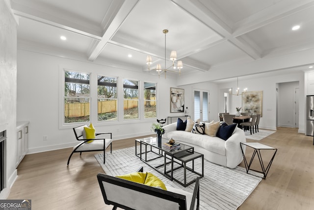 living area featuring a chandelier, baseboards, coffered ceiling, and light wood finished floors