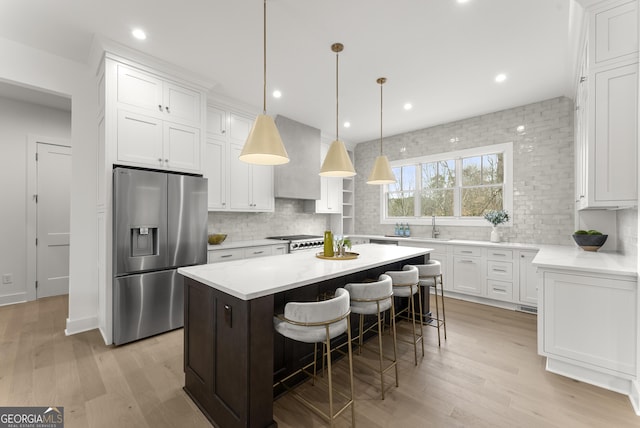 kitchen with stainless steel fridge, white cabinets, and a center island