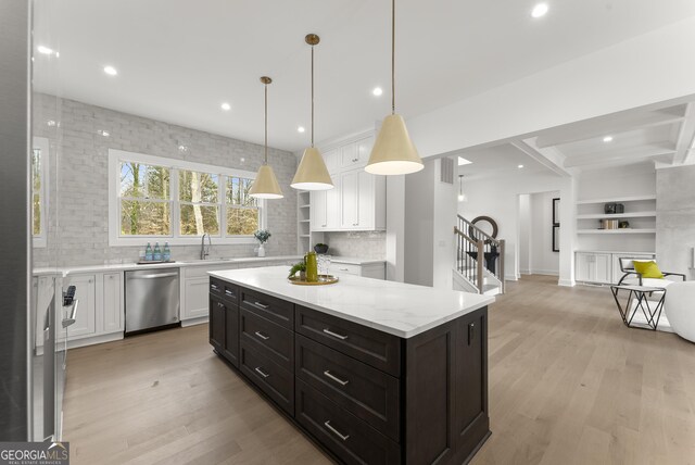 living room featuring beamed ceiling, coffered ceiling, light wood-type flooring, and an inviting chandelier