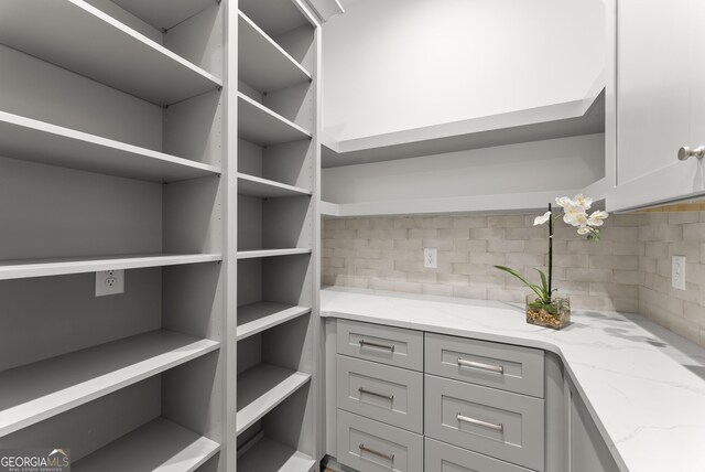 kitchen with white cabinetry, stainless steel dishwasher, light hardwood / wood-style floors, and hanging light fixtures