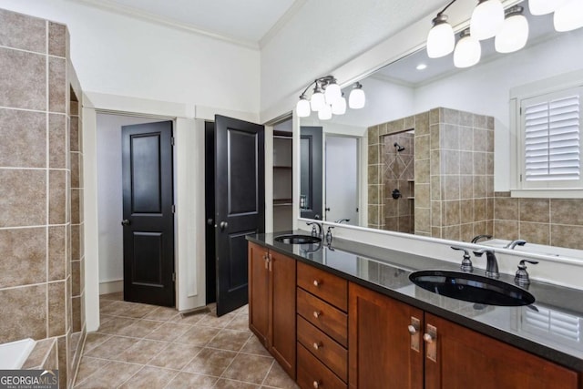 bathroom featuring crown molding, tile patterned floors, vanity, and a tile shower