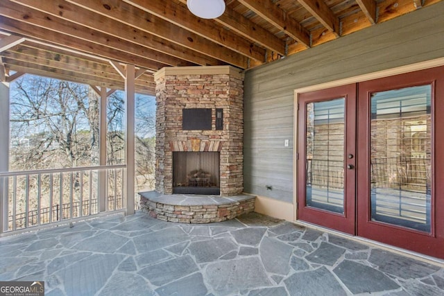 view of patio / terrace featuring french doors and an outdoor stone fireplace