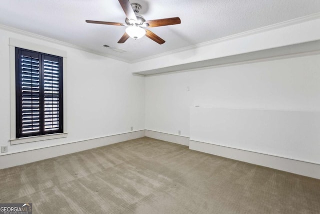 unfurnished room with ornamental molding, carpet, and ceiling fan