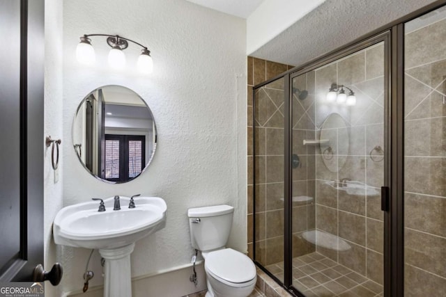 bathroom with a shower with door and toilet