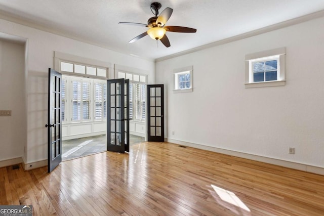 spare room featuring french doors, ceiling fan, crown molding, and light hardwood / wood-style flooring