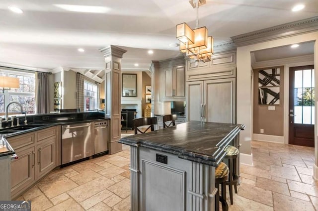 kitchen with sink, a kitchen bar, a kitchen island, decorative light fixtures, and stainless steel dishwasher