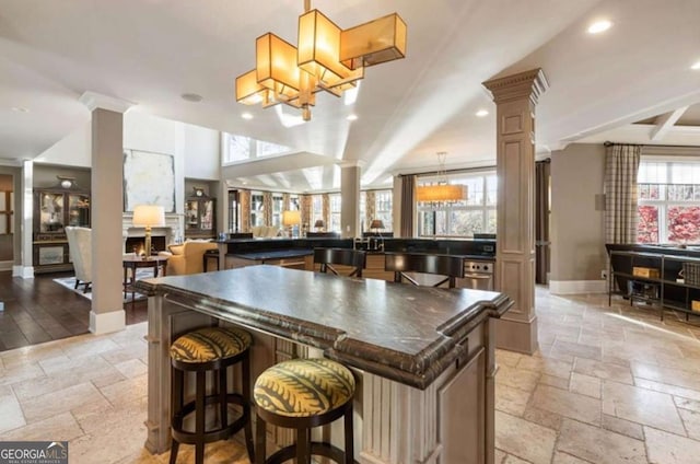 bar featuring decorative columns and hanging light fixtures