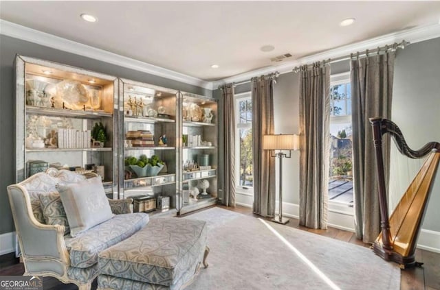 living area with ornamental molding and wood-type flooring