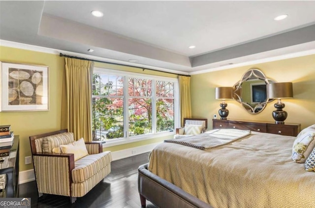 bedroom with crown molding, dark hardwood / wood-style floors, and a raised ceiling