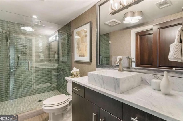 bathroom featuring vanity, toilet, and walk in shower