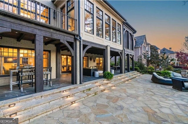 back house at dusk with a patio