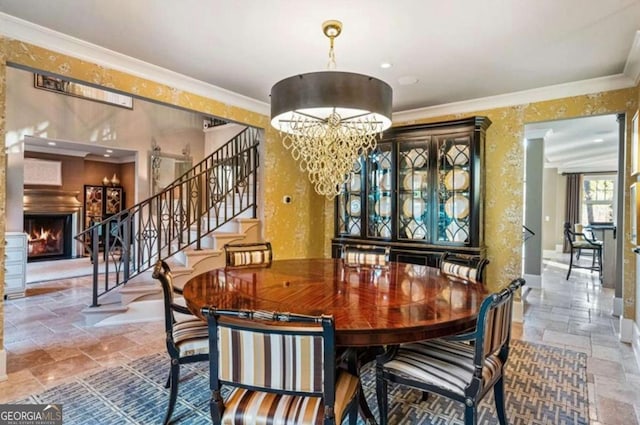 dining room featuring ornamental molding, an inviting chandelier, and a fireplace