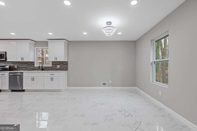 kitchen featuring white cabinetry, sink, tasteful backsplash, and stainless steel appliances