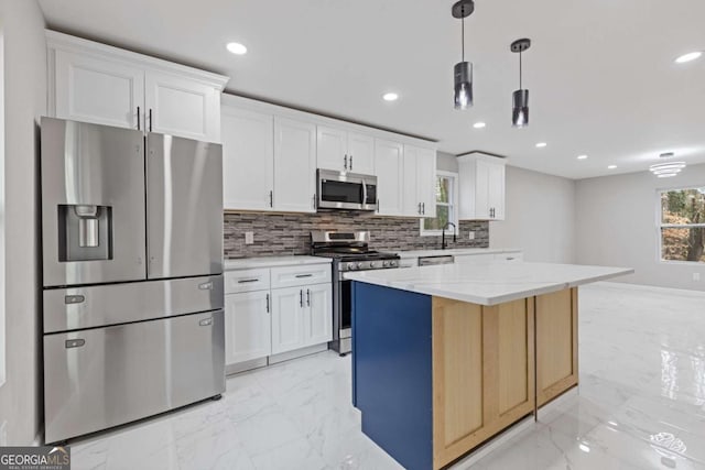 kitchen with pendant lighting, stainless steel appliances, white cabinets, a kitchen island, and decorative backsplash