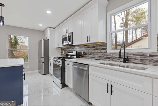 kitchen with white cabinetry, sink, decorative light fixtures, and stainless steel appliances