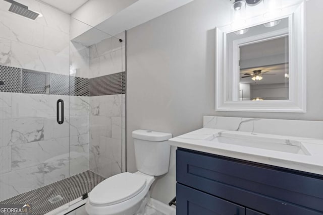 bathroom with walk in shower, ceiling fan, vanity, and toilet