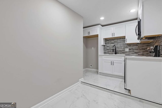 kitchen with sink, decorative backsplash, and white cabinets