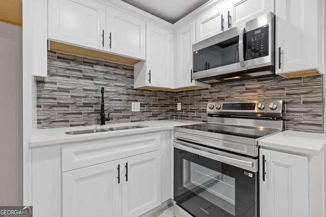 kitchen with white cabinetry, appliances with stainless steel finishes, sink, and decorative backsplash